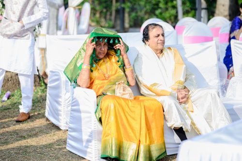 Groom’s aunt covering her face with saree to avoid sun during outdoor wedding at Pandit Farms Pune