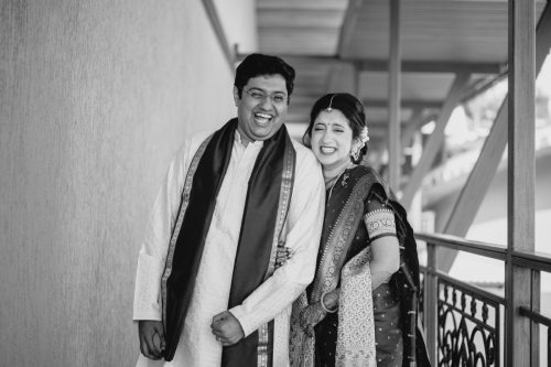 Bride and groom laughing together during candid black and white wedding couple portraits