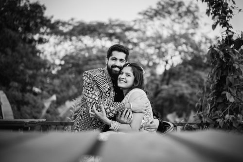 Bride and groom hugging during romantic black and white engagement couple portrait at Roots 9, Pune
