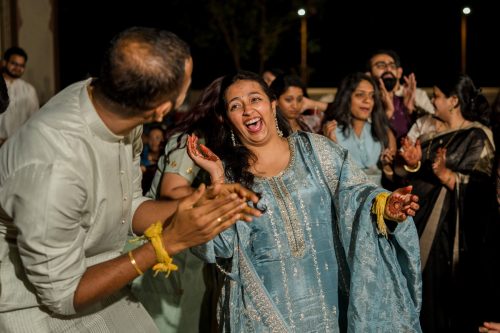 Bride dancing joyfully with friends during sangeet night at Dhepe Wada Pune wedding