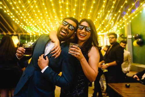 Couple enjoying cocktail party with drinks under warm lights at Tipsy Duckling Pune wedding