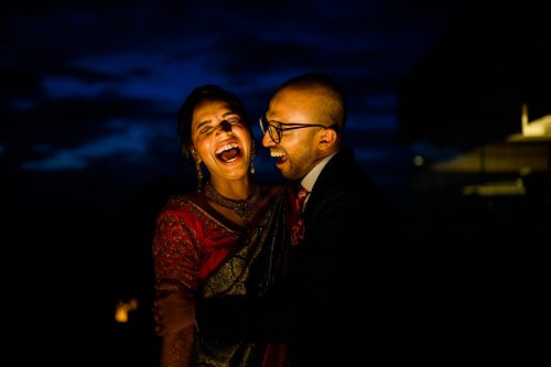 Bride and groom laughing together during dramatic night couple portraits at a wedding in the evening at hyatt hotel pune