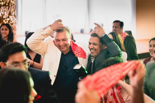 Bride and groom fathers dancing with drinks during cocktail party at PYC Pune wedding