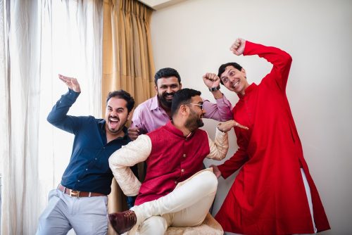 Groom and friends making funny poses during wedding portraits in Mumbai