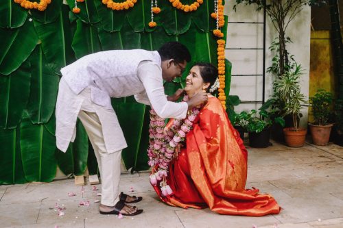 groom placing garland on bride during marathi wedding varmala