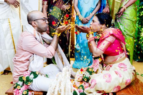 bride and groom blowing akshata during funny and happy telugu-kerala- maharashtrian wedding ceremony