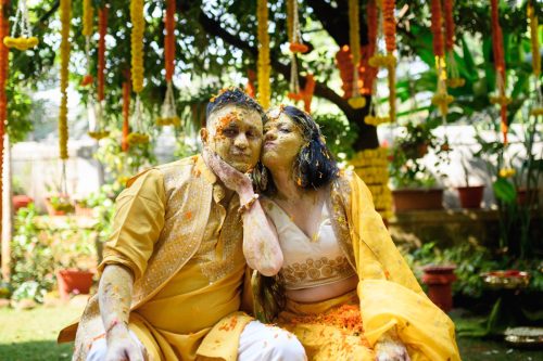 Bride and groom laughing together during a Maharashtrian haldi wedding ceremony at the bride's residence in Pune