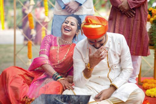 A funny candid moments during mangalsutra as the bride and groom laugh during maharashtrian wedding