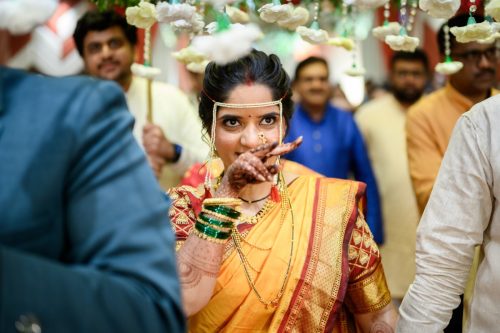 marathi bride walking toward groom during mangalashtak ceremony and looking towards him with love and eyes