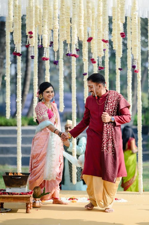 bride and groom walking hand in hand during phere marathi wedding