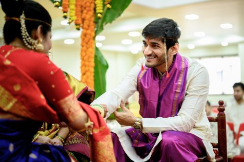 groom looking lovingly at bride during sutraveshtan marathi wedding ceremony