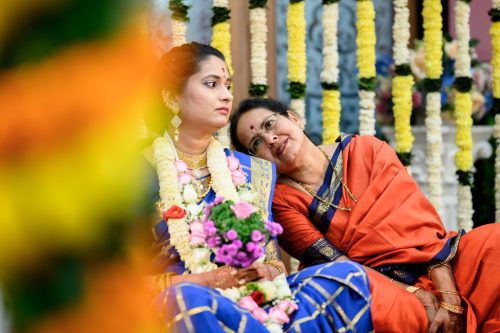 Mother resting her head on bride’s shoulder during Tamil Brahmin wedding at Siddharth Palace Pune