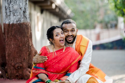 Bride and groom smiling widely during playful candid wedding couple portraits during maharashtrian wedding at dhepe wada, pune