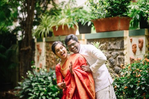 Bride and groom laughing together during playful garden wedding couple portraits