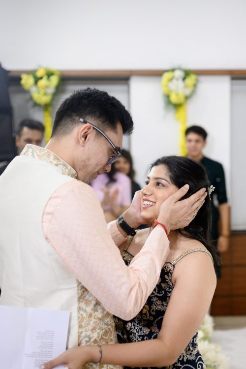 groom holding bride face affectionately during sangeet ceremony
