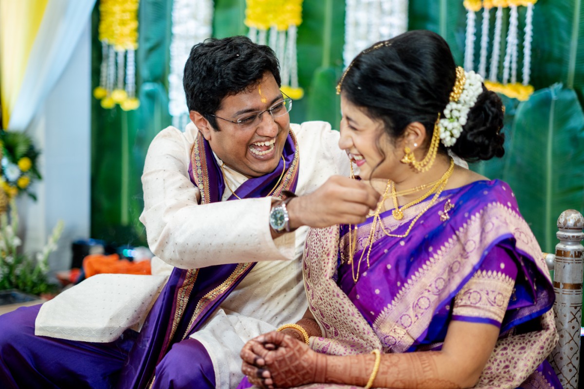 Groom laughing as he ties mangalsutra while bride smiles during Maharashtrian wedding ceremony at Marigold Pune