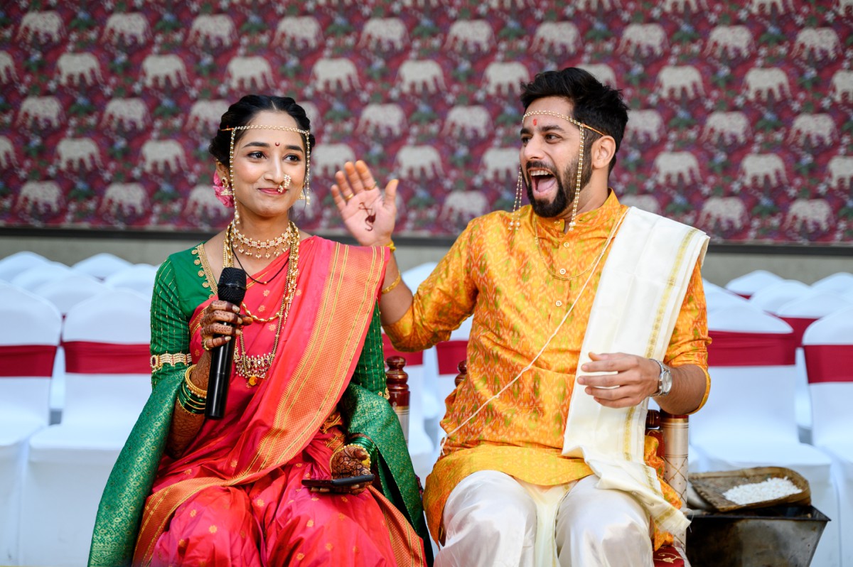 Bride saying ukhana while groom laughs during Maharashtrian wedding ceremony at Harshal Hall Pune