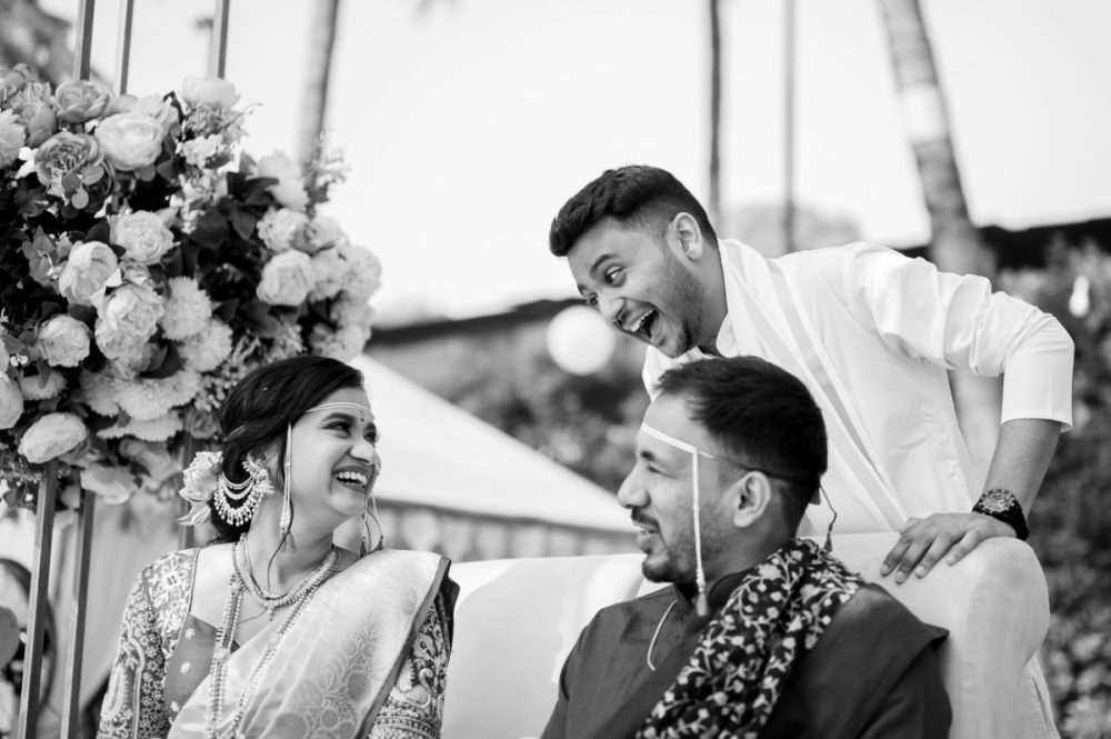 Bride and groom laughing with bride's brother during a candid moment at a Maharashtrian wedding ceremony during kaanpili in pune at Pandit farms
