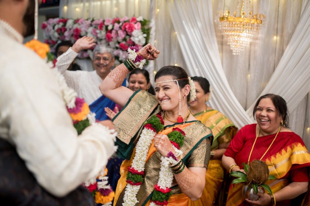 Bride rejoicing playfully during as she wins putting the garland first during Mangalasthaka in Maharashtrian wedding ceremony at Shruti Mangal Karyalaya in Pune