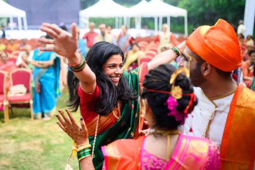 Friend surprising the bride and groom with a joyful hug during a Maharashtrian wedding at Keshav Baug Pune