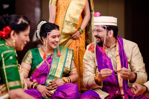 bride and groom lookinag at each other and laughing during maharashtrian wedding ceremony