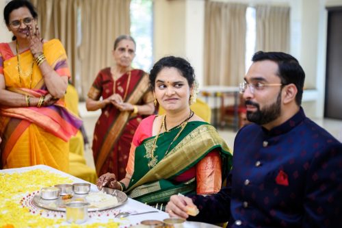 bride smiling and raising eyebrow during ukhana ritual marathi wedding looking funnily at the groom